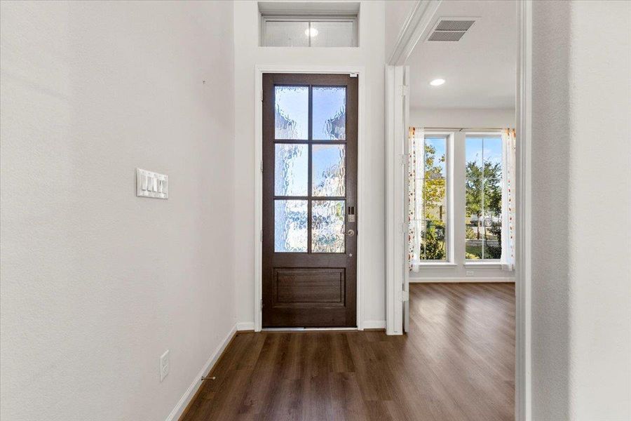 Entrance foyer with dark wood-type flooring and baseboards Entrance foyer with dark wood-type flooring and baseboards