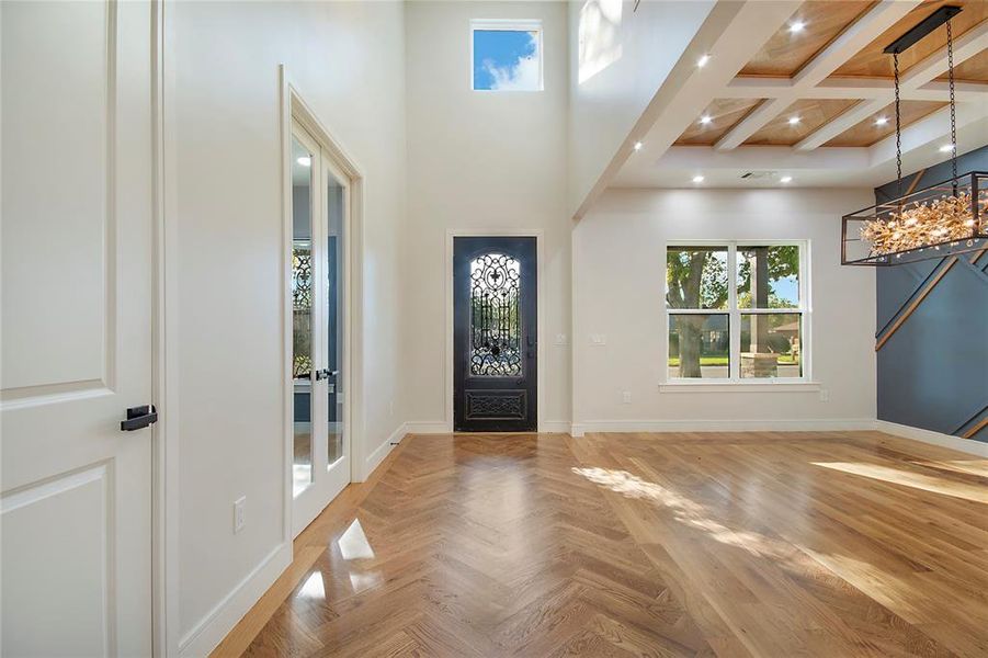 Entryway featuring beamed ceiling, coffered ceiling, and a towering ceiling