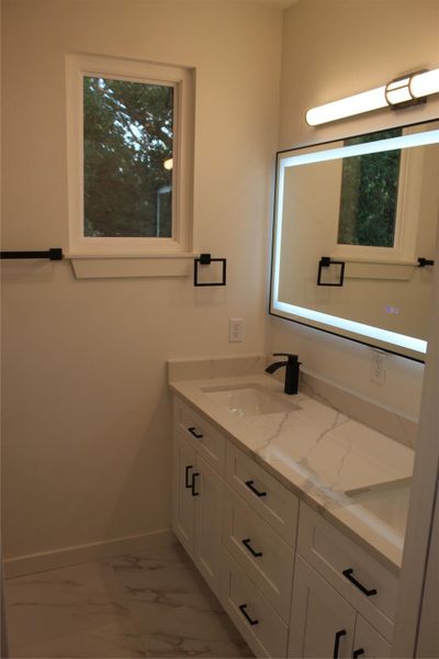 A well-appointed bath features a double vanity and sleek modern fixtures, ready for daily routines.