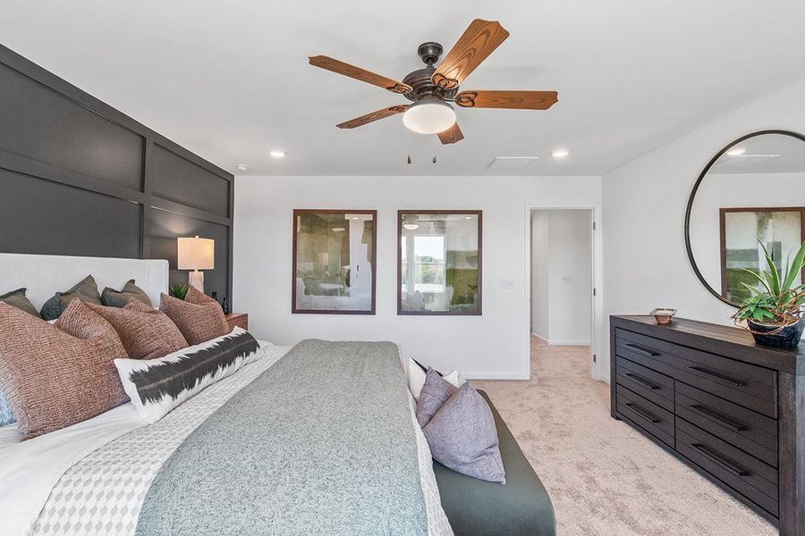 A bedroom with a bed and a fan.