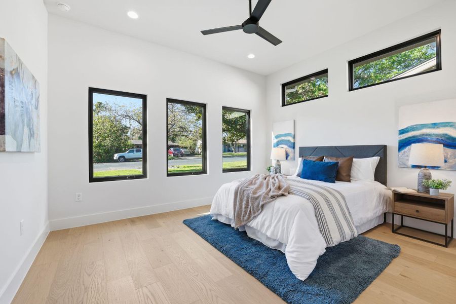 Bedroom with multiple windows, light wood-type flooring, a ceiling fan, and recessed lighting