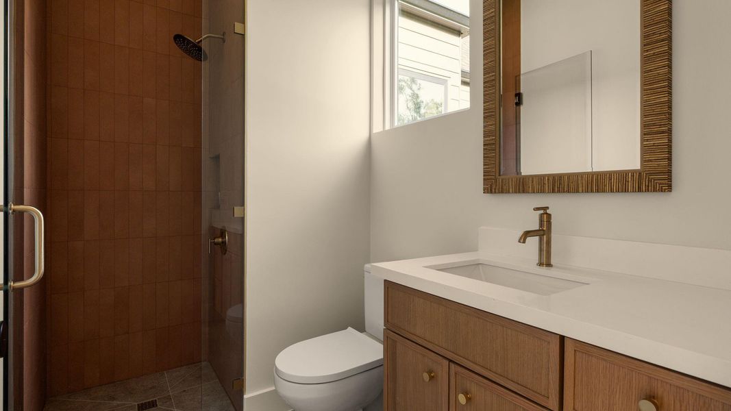 A sleek, contemporary bathroom with a glass-enclosed shower and modern vanity. A sleek, contemporary bathroom with a glass-enclosed shower and modern vanity.
