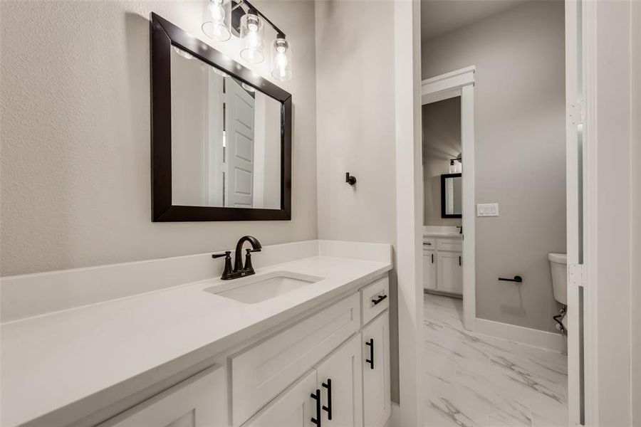 Bathroom featuring tile patterned floors, toilet, and vanity