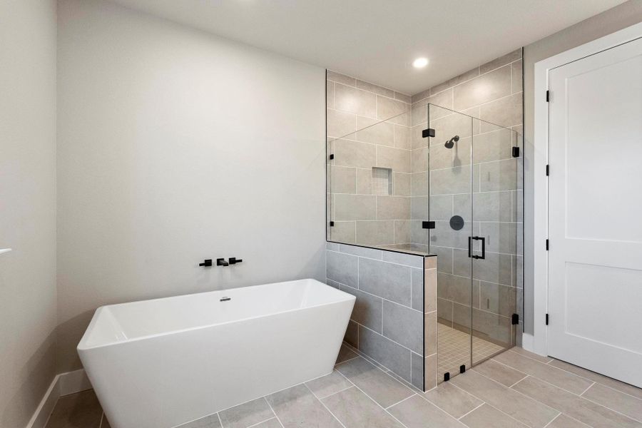 Full bathroom with a shower stall, a freestanding tub, and recessed lighting