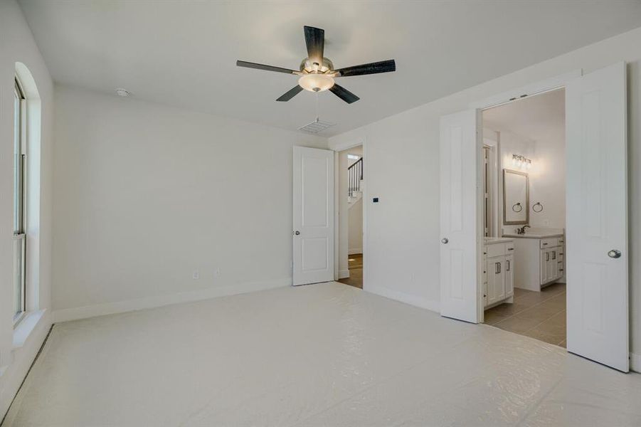 Spacious room featuring a contemporary ceiling fan with integrated lighting, an arched window, and a white six-panel door