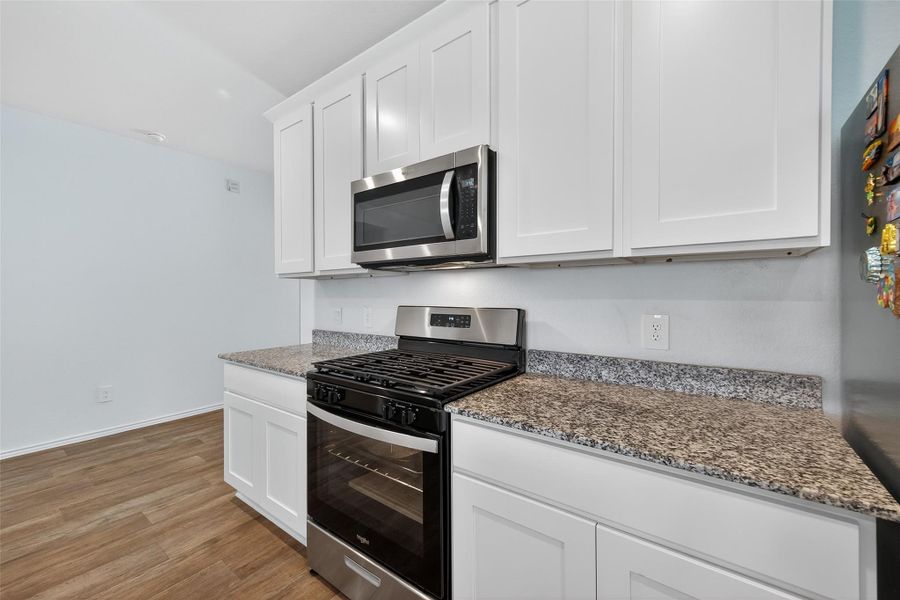 A chef’s kitchen boasting granite surfaces, custom cabinetry, and premium stainless steel appliances.