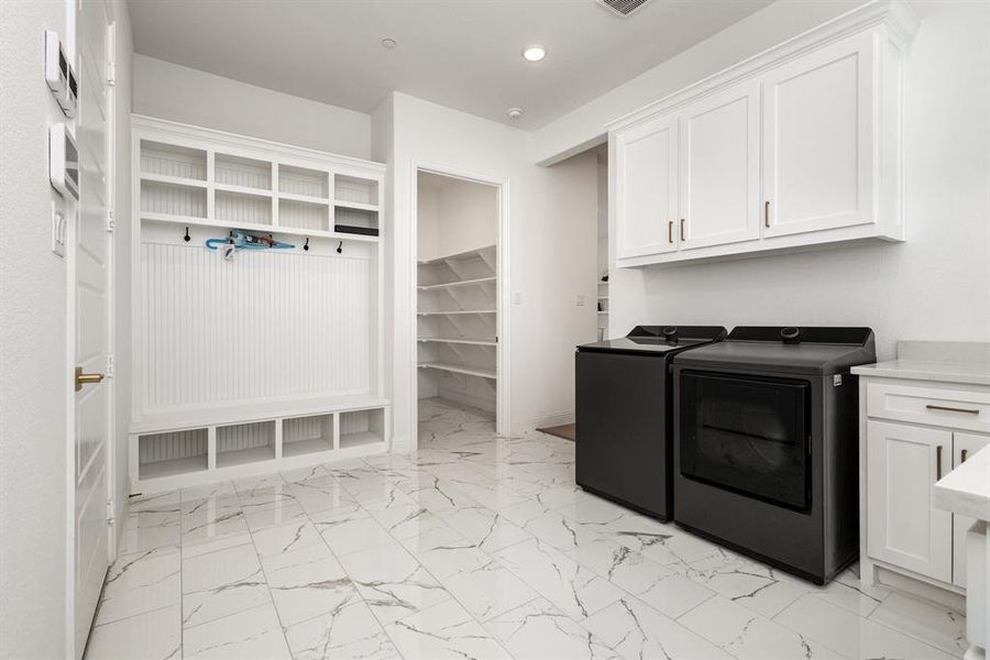 Washroom featuring light marble finish floors, separate washer and dryer, recessed lighting, and cabinet space