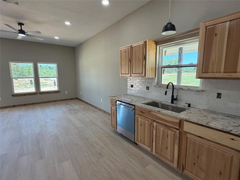 Open-concept living space featuring wood-finish flooring, recessed lighting, and a ceiling fan