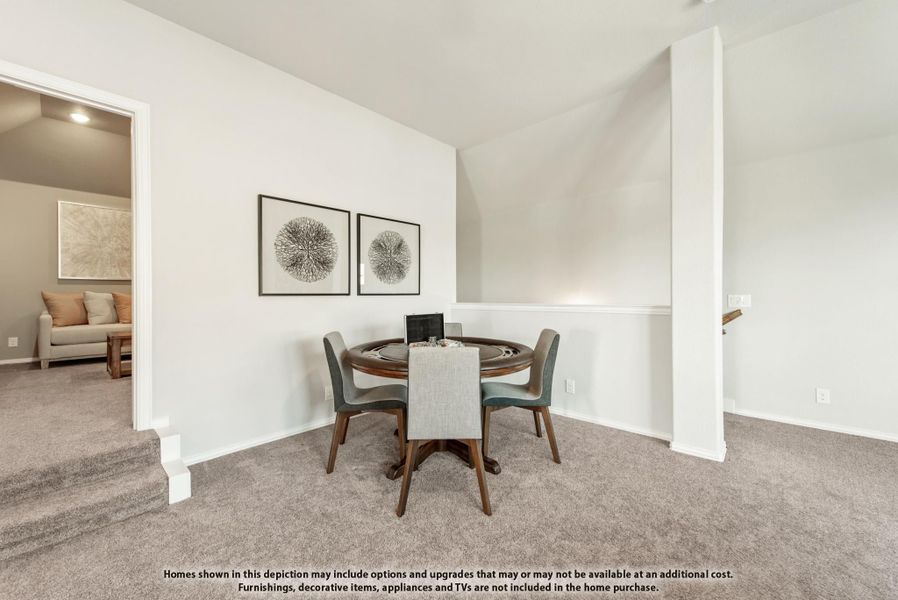 Dining area with round wood table, four chairs, vaulted ceiling, and carpet flooring