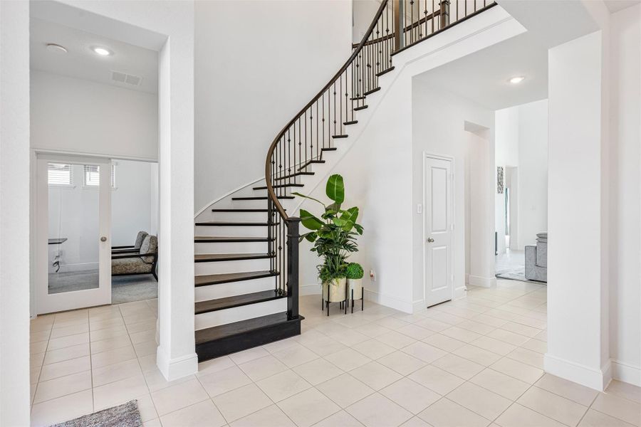 Step into your grand entrance and foyer, where solid wood stairs and an elegant iron banister create a stunning first impression. The hallway flows seamlessly into a secluded study and a convenient half bath.