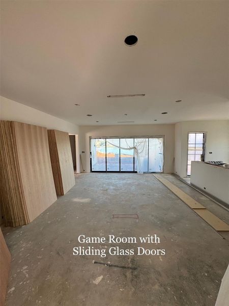 Expansive Game Room with wall-to-wall Sliding Glass Doors that open to the backyard, blending indoor and outdoor living.