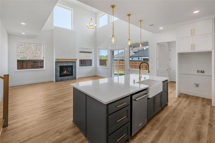 Kitchen with a wealth of natural light, sink, decorative light fixtures, and light wood-type flooring