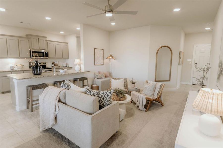 Carpeted living room featuring ceiling fan