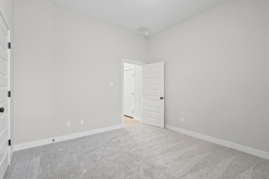 Spare room featuring light colored carpet and baseboards