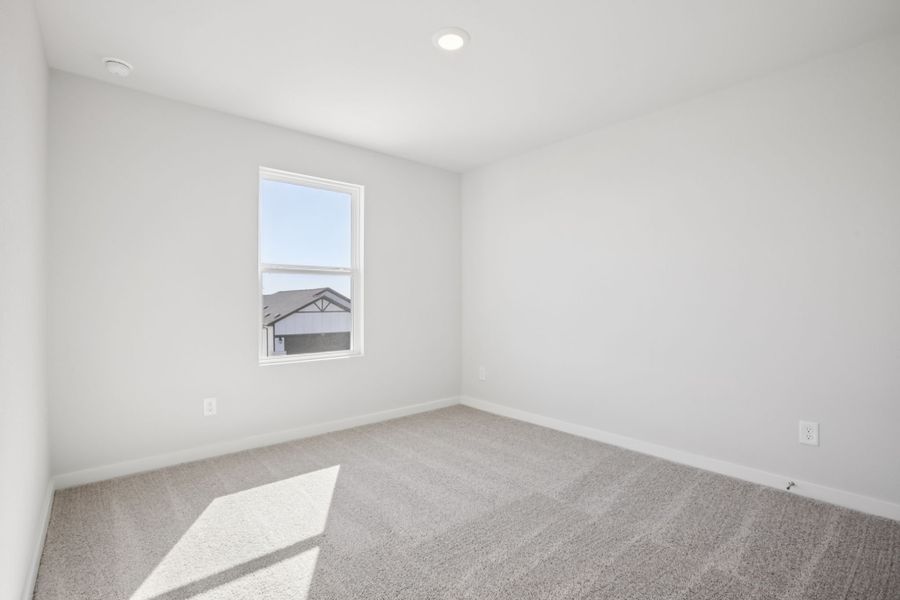 A room with a window and a rug.