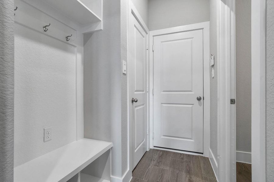 This dedicated area features a custom built-in bench with hooks, perfect for organizing coats, bags, and shoes right off the main hallway, keeping the rest of the home tidy. This dedicated area features a custom built-in bench with hooks, perfect for organizing coats, bags, and shoes right off the main hallway, keeping the rest of the home tidy.