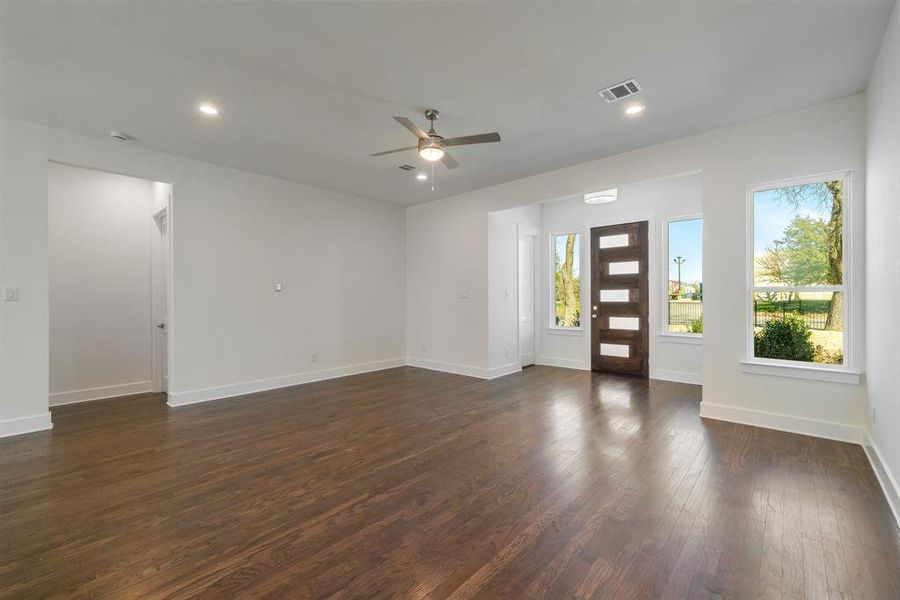 Unfurnished room with ceiling fan, dark hardwood / wood-style flooring, and a wealth of natural light