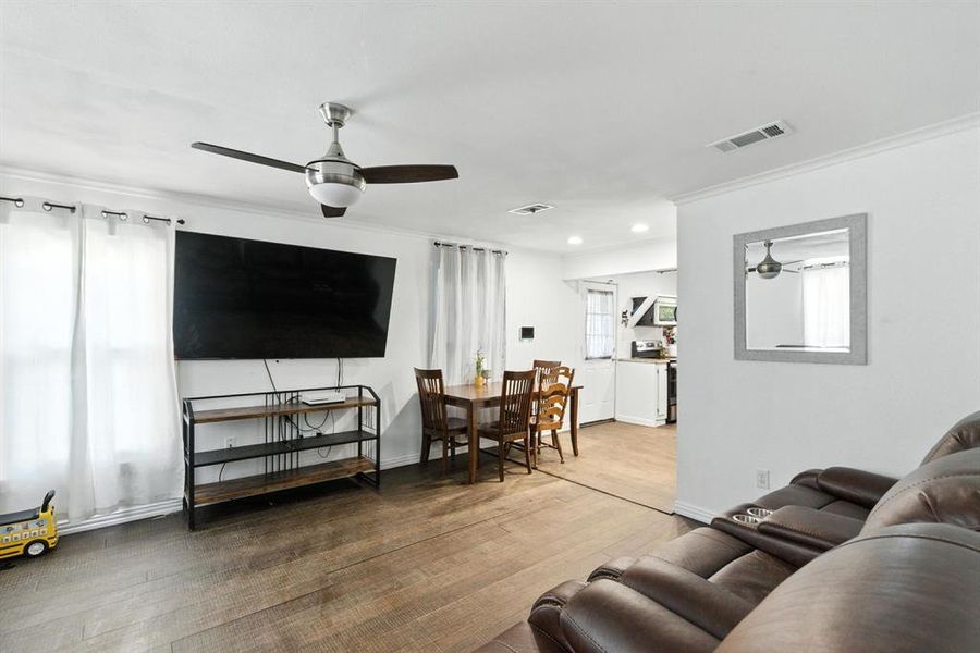 Living area with a ceiling fan, crown molding, wood finished floors, and recessed lighting