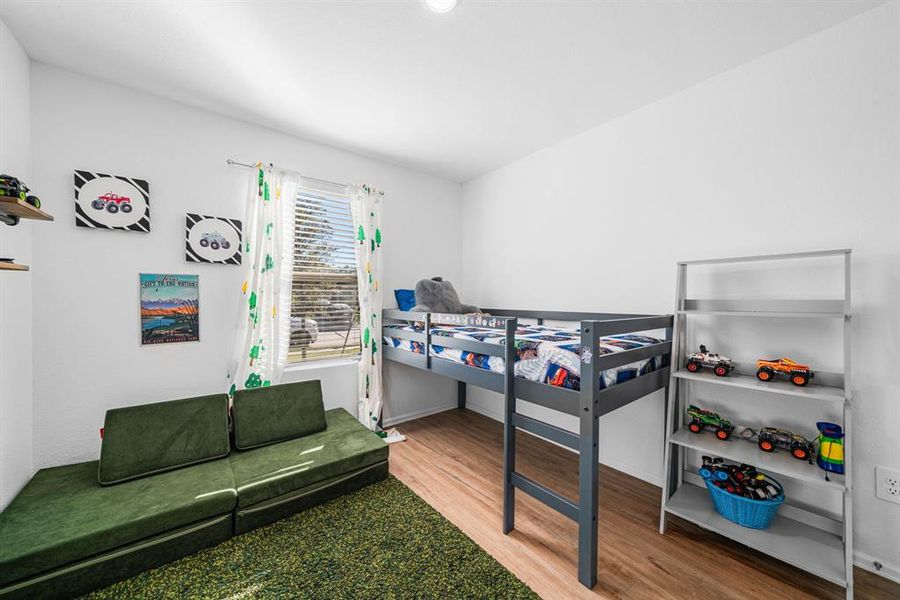 The 1st bedroom, located just off the entry, offers a peaceful retreat with ample space, large windows that fill the room with natural light, and a cozy atmosphere perfect for rest or relaxation.