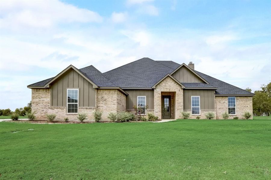 Craftsman-style home featuring a shingled roof, board and batten siding, a chimney, and a front yard Craftsman-style home featuring a shingled roof, board and batten siding, a chimney, and a front yard