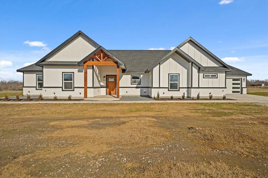 Modern farmhouse style home with a garage and a front lawn