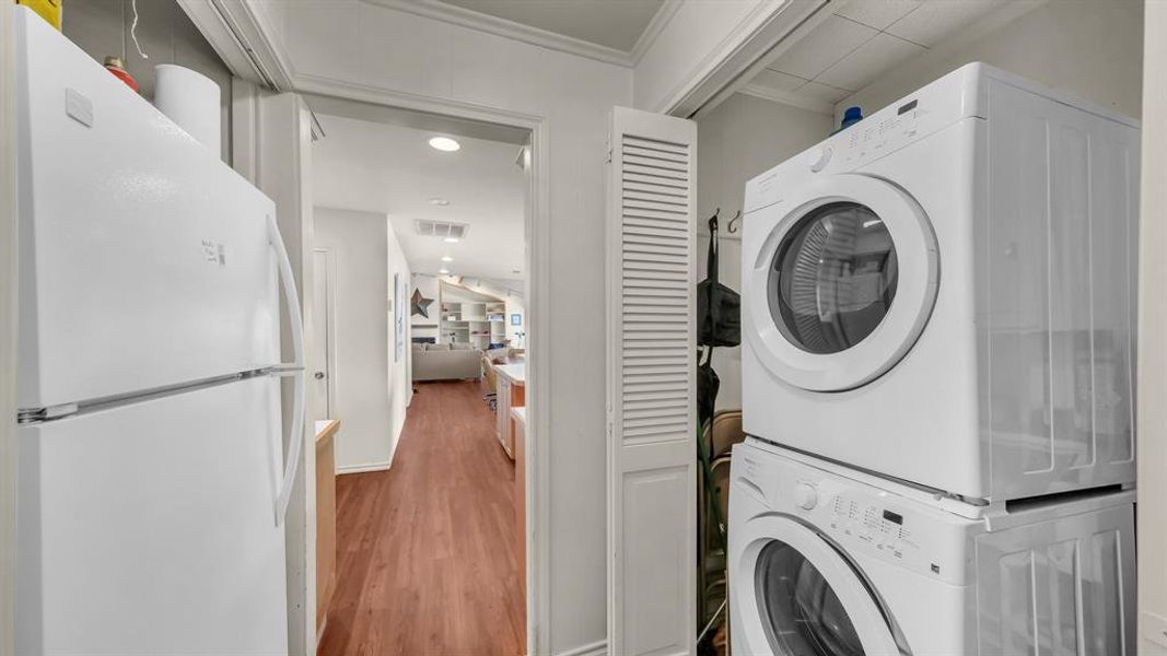 Laundry area with stacked washing machine and dryer, and extra refrigerator