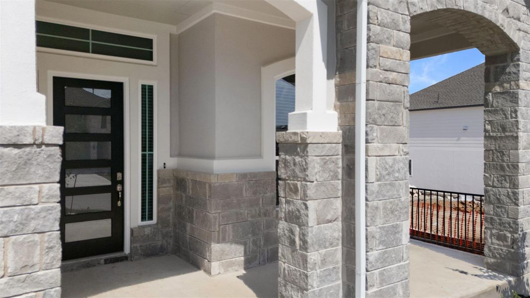 Doorway to property with stone siding and stucco siding