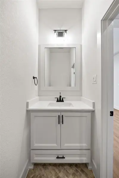 Bathroom featuring vanity and a textured wall
