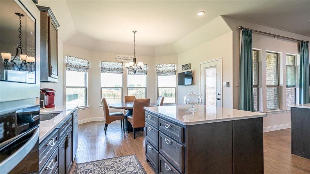 Kitchen area featuring dark wood-finish cabinetry, light-toned countertops, and wood-finish flooring