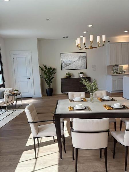Dining space with recessed lighting, light wood-style flooring, and a chandelier
