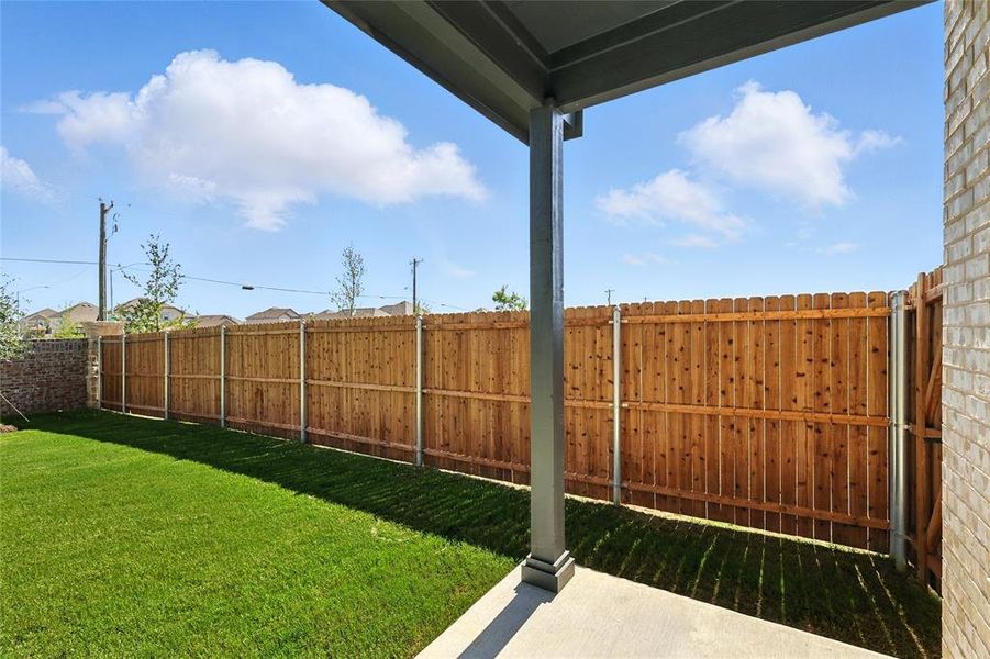Fenced backyard with a patio area Fenced backyard with a patio area