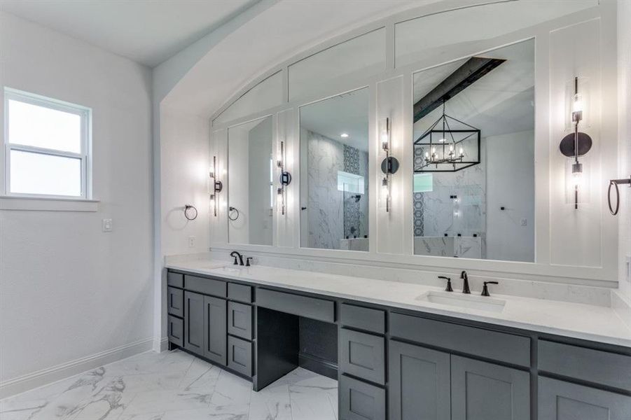 Primary bathroom featuring vanity, a chandelier, and a tile shower