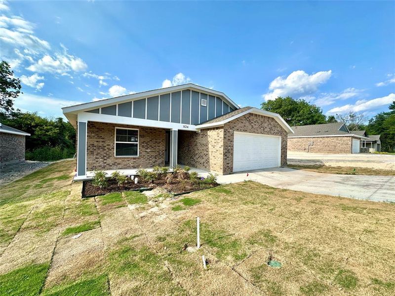 View of front of house featuring a garage and a front lawn