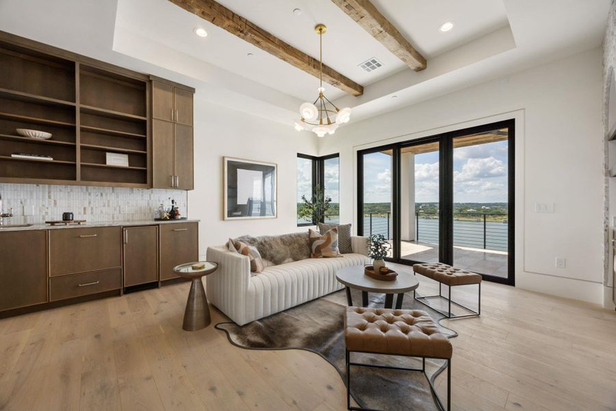 A refined living area boasts exposed wood beams and broad sliding doors opening to expansive water views. A refined living area boasts exposed wood beams and broad sliding doors opening to expansive water views.
