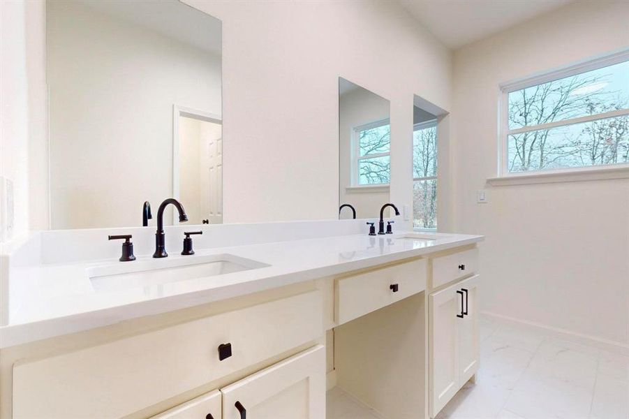Bathroom with double vanity, baseboards, marble finish floor, and a sink