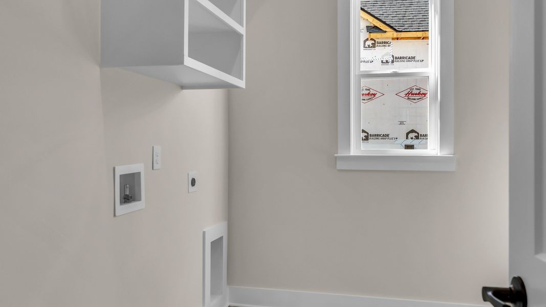 Dedicated laundry room with hookups and window (Representative of completed home)