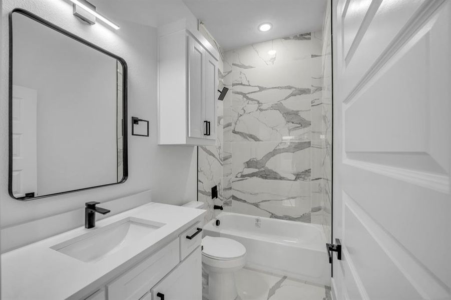 Full bathroom with vanity, toilet, and tiled shower / bath combo