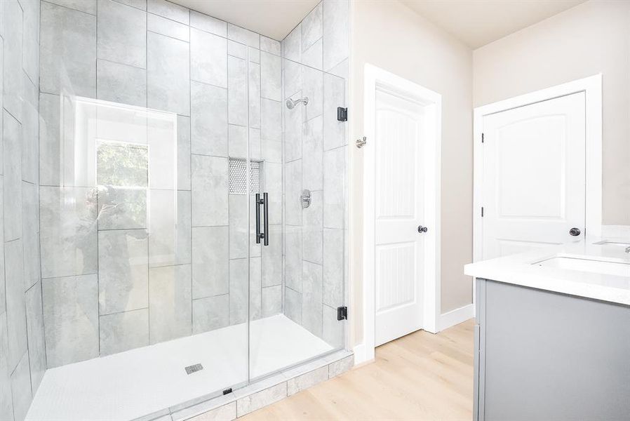 Primary En-Suite Bathroom with Double Sinks, Large Shower, and Walk-In Closet