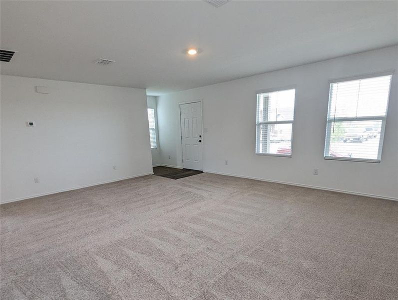 A spacious living area with warm natural light, perfect for relaxation and gatherings.