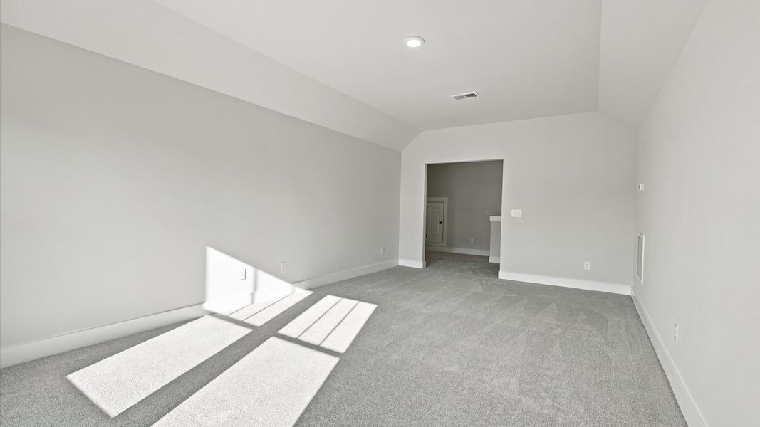 Vibrant carpeted bonus room offering flexibility as a study nook, game room, or second family space at Walnut Ridge