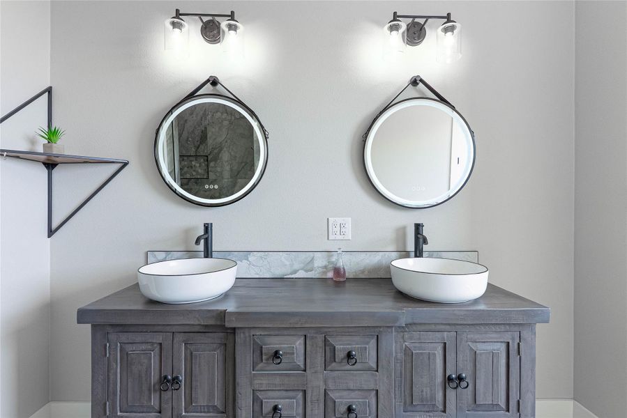 Double vanities and modern finishes create a luxurious bathroom.