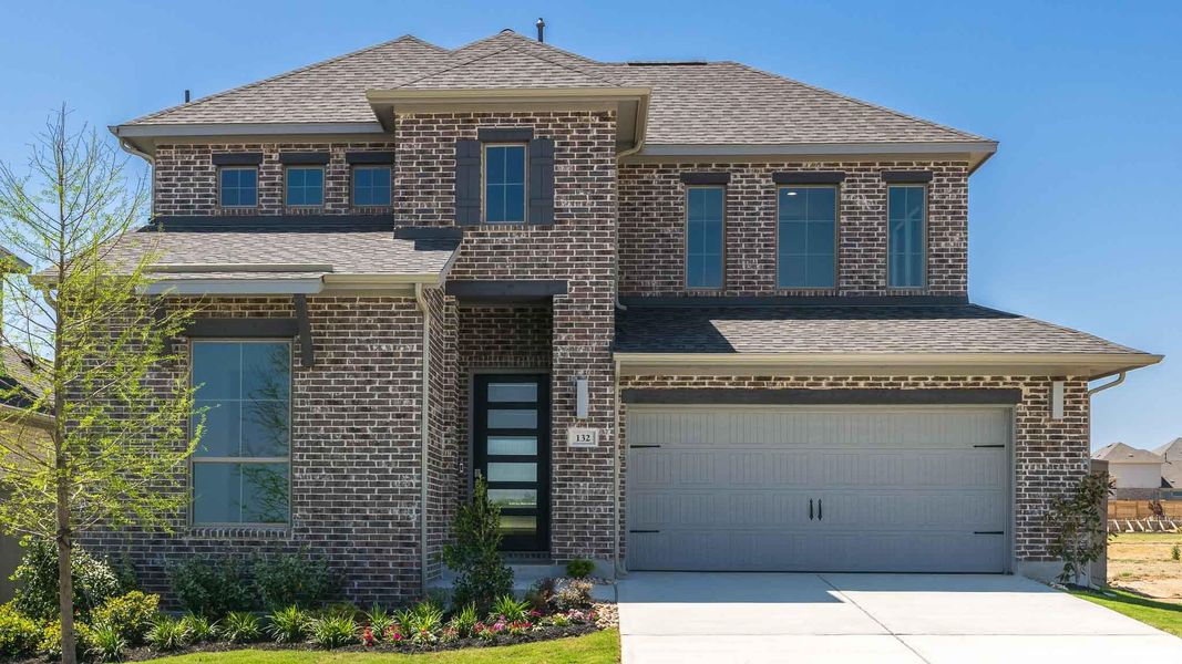 Traditional-style house with brick siding, an attached garage, driveway, and a shingled roof Traditional-style house with brick siding, an attached garage, driveway, and a shingled roof