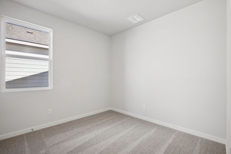 A room with a window and a rug.