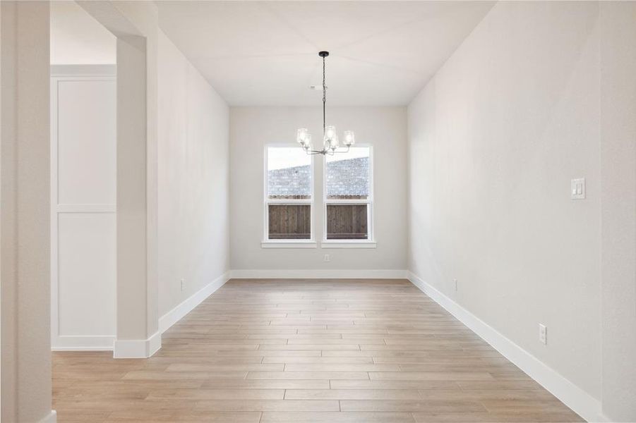 Unfurnished dining area with light hardwood / wood-style floors and a chandelier