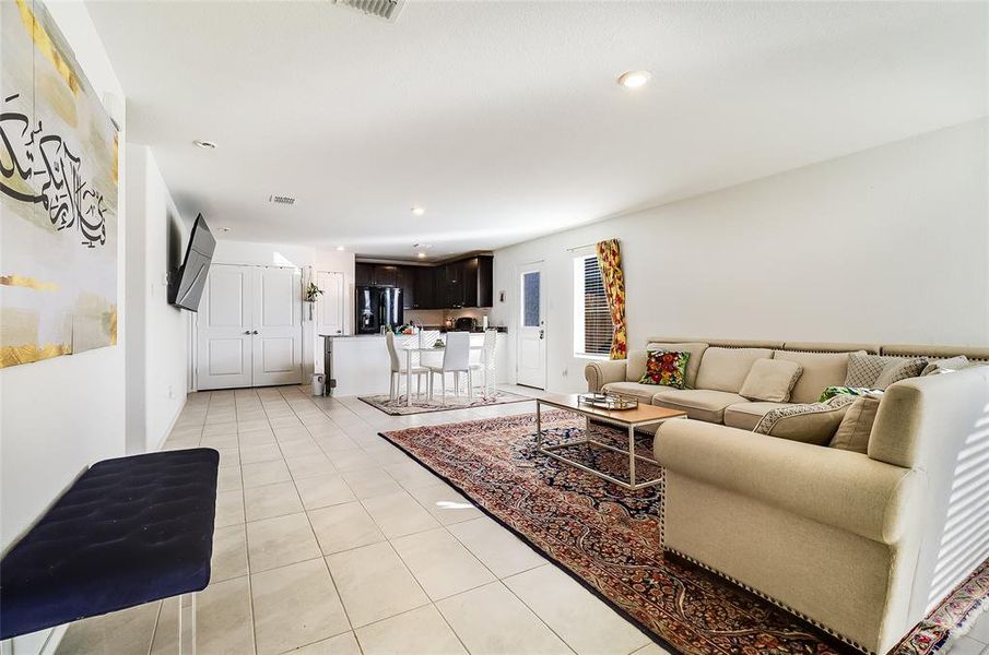 Living room with light tile patterned floors and recessed lighting