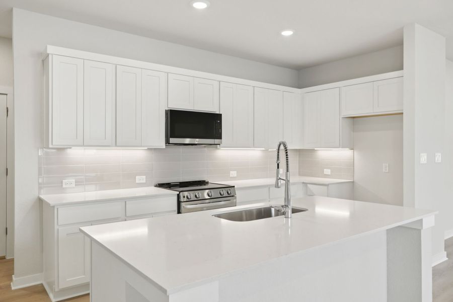 A kitchen with white cabinets.