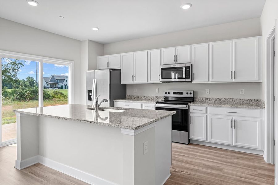 A kitchen with white cabinets.