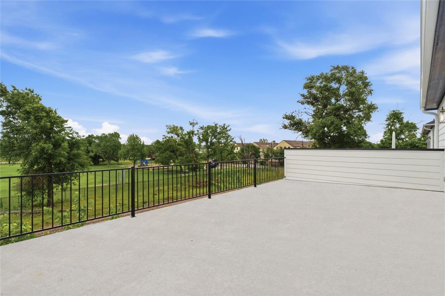 A spacious rooftop terrace overlooks American Legion Park, offering an open-air setting with scenic green views.