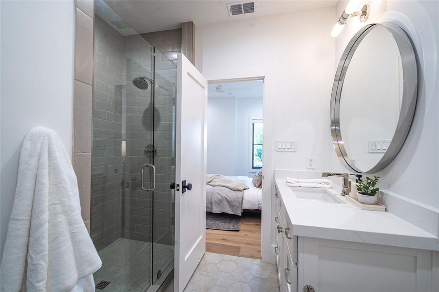 Bathroom with vanity, wood-type flooring, and a shower with door