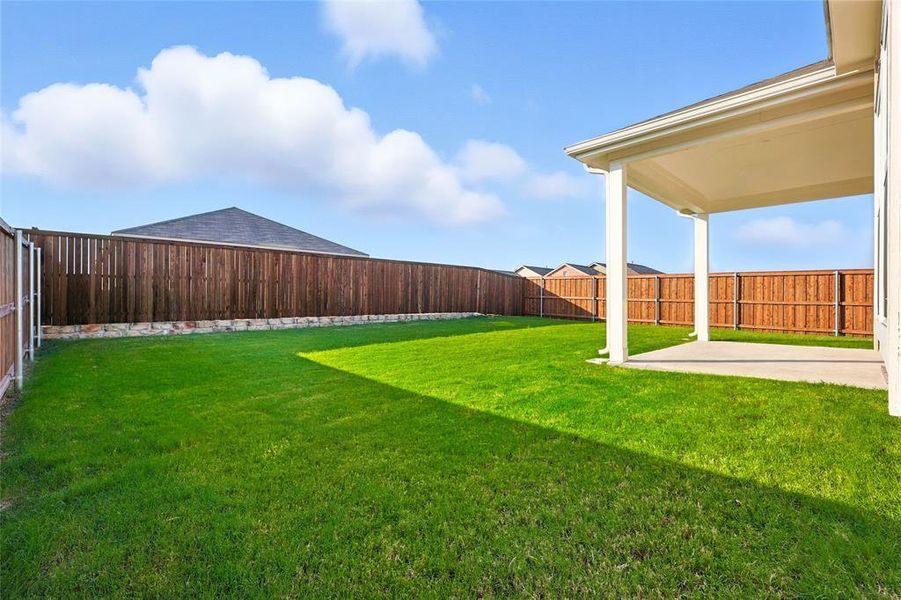 Fenced backyard with a patio area Fenced backyard with a patio area